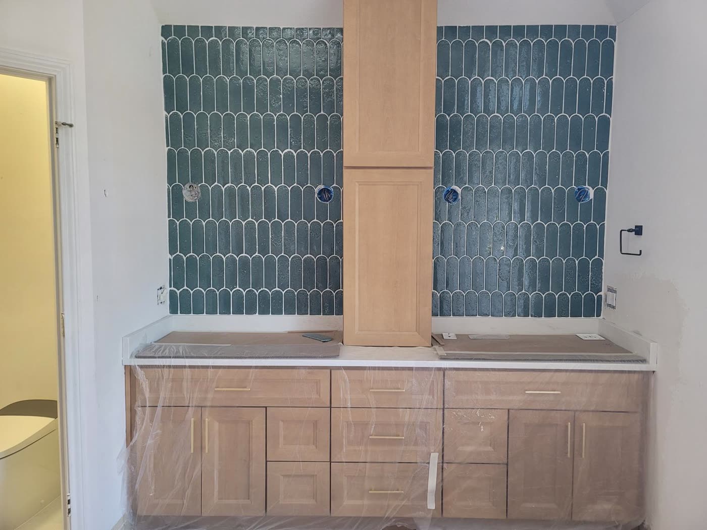 Bathroom with warm wood double vanity and marble floors in Richardson, TX